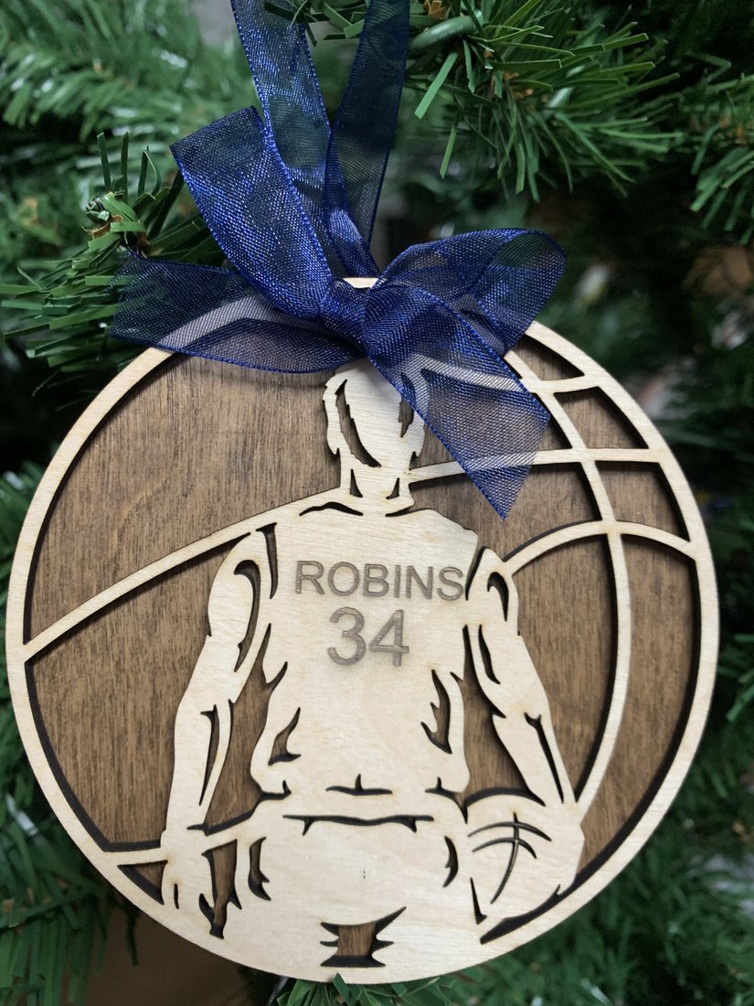Personalized basketball ornament engraved with player name Robins and number 34, hanging on a Christmas tree