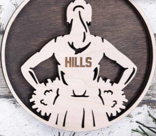 Personalized cheerleader ornament engraved with the team name Hills